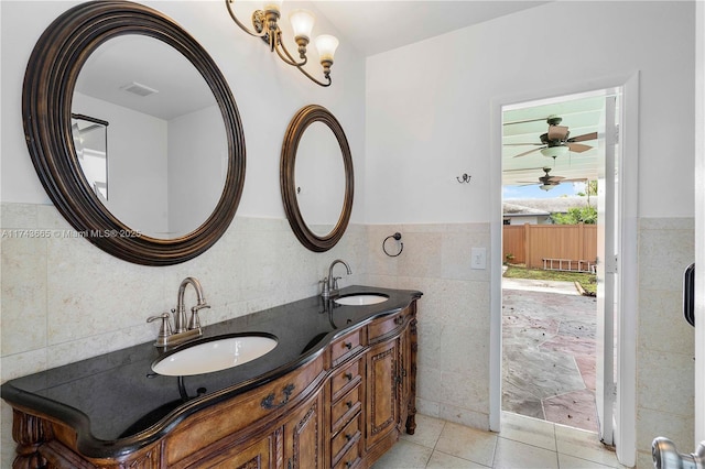 bathroom with visible vents, a sink, tile walls, and tile patterned floors