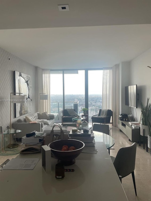 living room featuring expansive windows, visible vents, and wallpapered walls