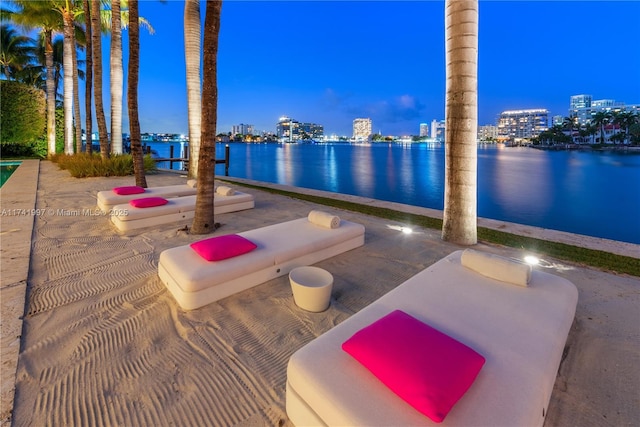 patio terrace at dusk with a water view and a city view