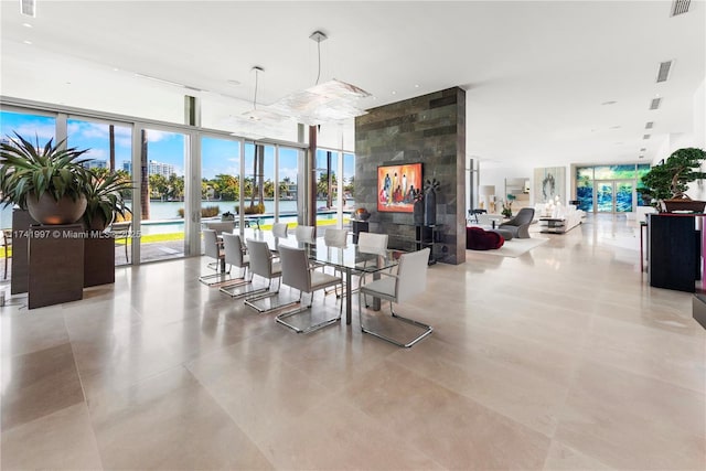 dining area with a water view, visible vents, and floor to ceiling windows