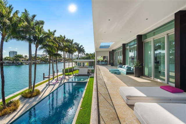 pool with a water view, a patio, and outdoor lounge area