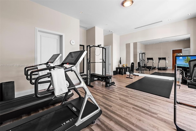 workout area with baseboards and wood finished floors