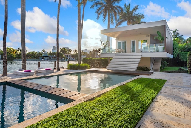 outdoor pool featuring stairway and a patio