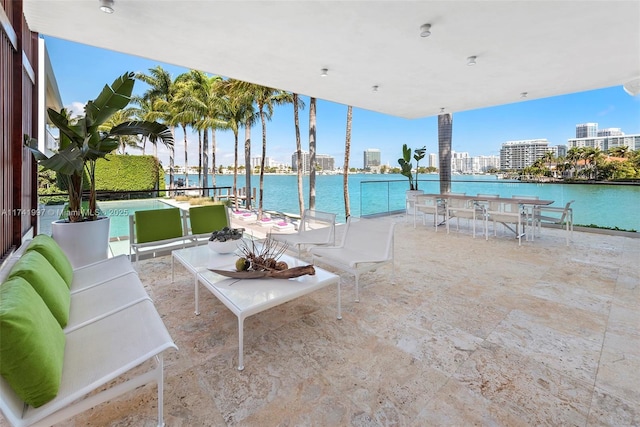 view of patio / terrace featuring a city view, a water view, and an outdoor living space