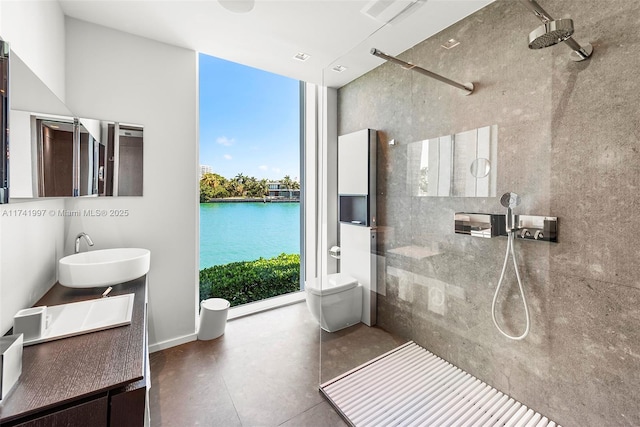 full bathroom featuring a walk in shower, toilet, a water view, a sink, and floor to ceiling windows