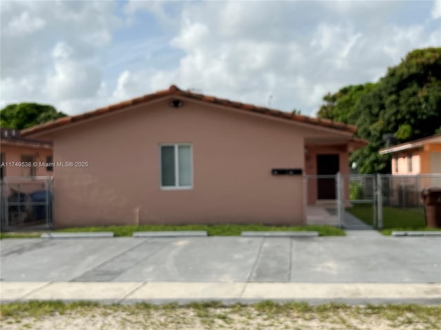 view of front facade with a gate, fence, and stucco siding