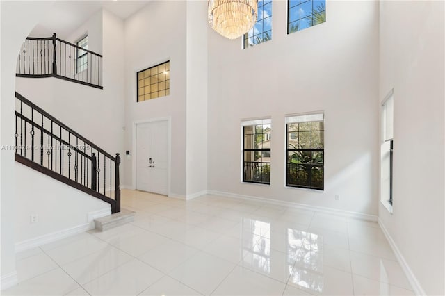 foyer with a healthy amount of sunlight, baseboards, and stairs