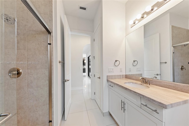 full bathroom featuring tile patterned flooring, visible vents, a tile shower, and vanity