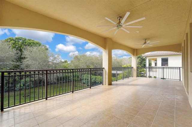 view of patio with a ceiling fan and a balcony