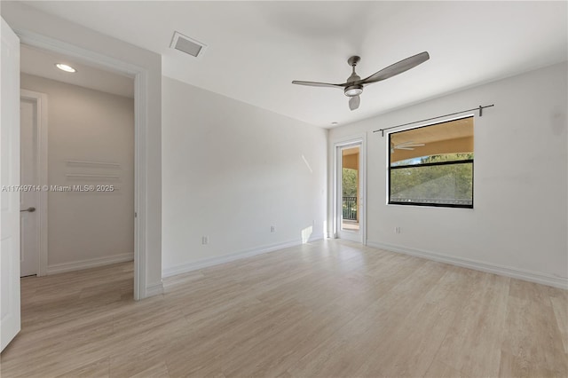 spare room with light wood-style floors, visible vents, ceiling fan, and baseboards