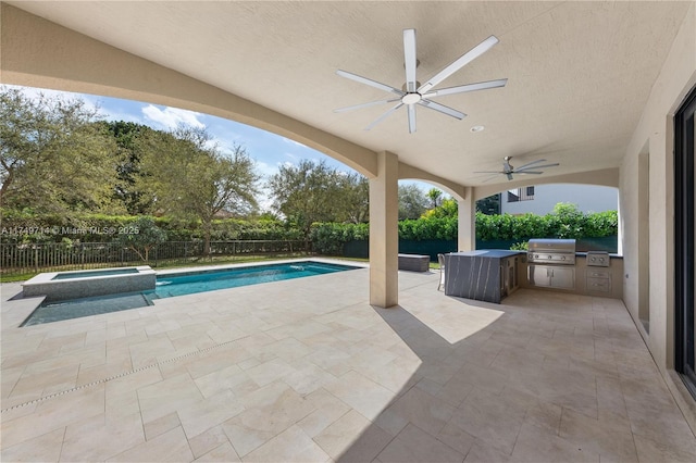 view of pool with a pool with connected hot tub, an outdoor kitchen, a patio area, a grill, and a fenced backyard