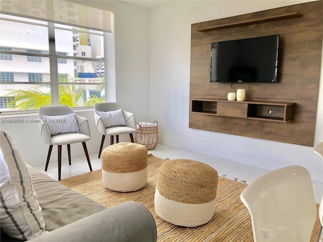 sitting room with light tile patterned floors, baseboards, and a healthy amount of sunlight