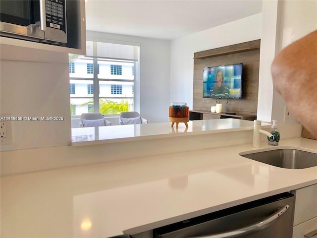 kitchen featuring stainless steel appliances, light countertops, and a sink