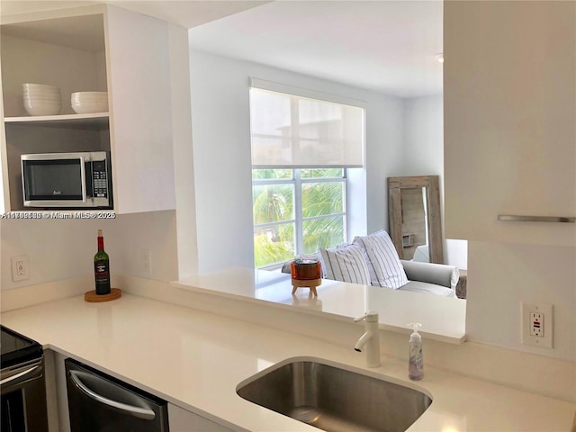 kitchen with light countertops, appliances with stainless steel finishes, and a sink