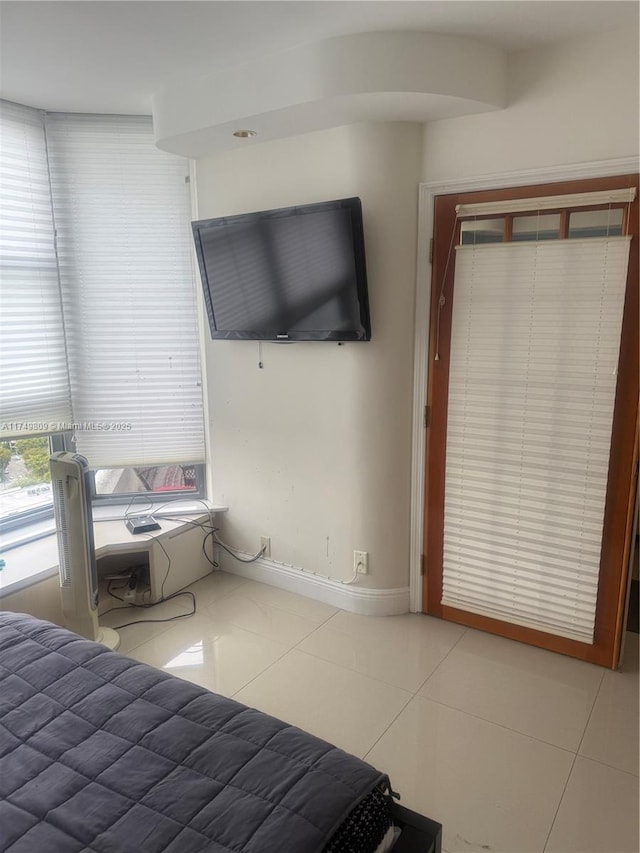 unfurnished bedroom featuring tile patterned flooring and baseboards