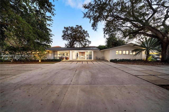 ranch-style home featuring a standing seam roof and metal roof