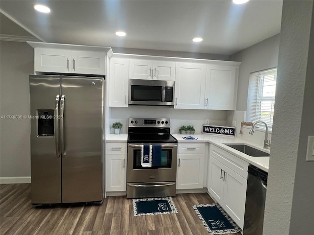 kitchen with white cabinets, appliances with stainless steel finishes, light countertops, and a sink