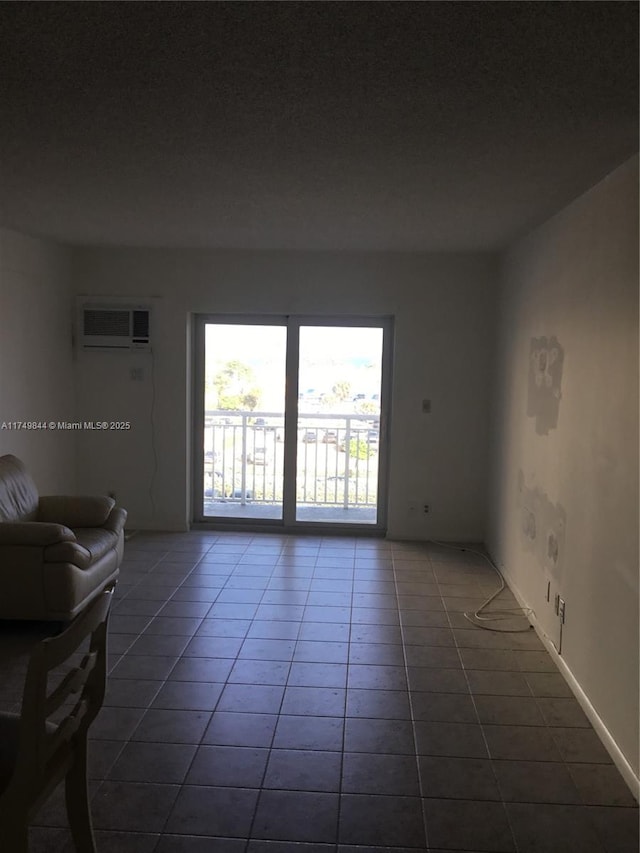 unfurnished living room with a wall mounted AC and tile patterned flooring