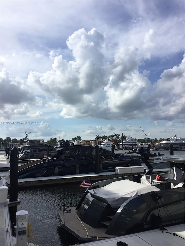 view of parking featuring a dock and a water view