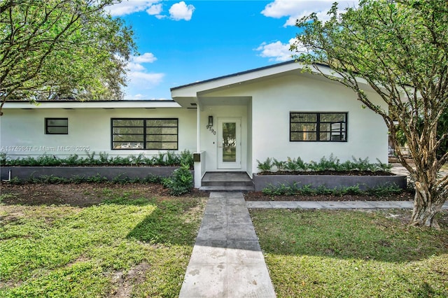 view of front of property with a front yard and stucco siding