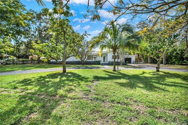 view of front of property featuring aphalt driveway and a front yard