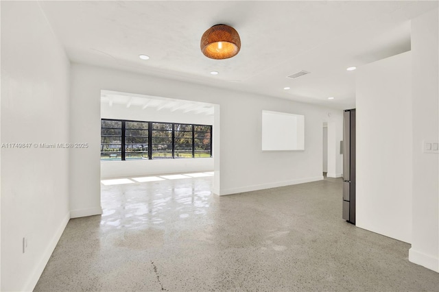 unfurnished room with speckled floor, recessed lighting, visible vents, and baseboards