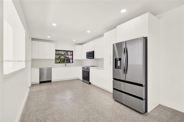 kitchen featuring appliances with stainless steel finishes, white cabinetry, light countertops, and modern cabinets