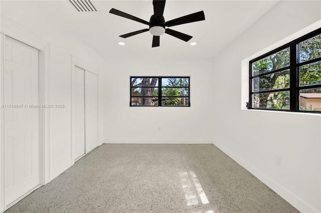 empty room featuring speckled floor, visible vents, baseboards, recessed lighting, and ceiling fan