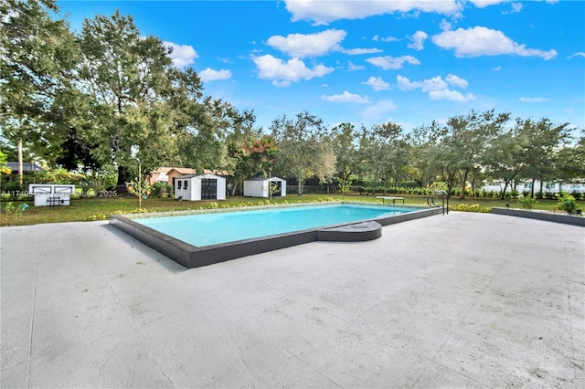 view of pool with a fenced in pool, a yard, an outbuilding, a storage unit, and a patio