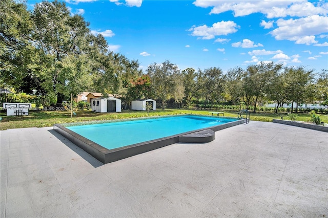 outdoor pool featuring a patio area, a lawn, a storage unit, and an outdoor structure