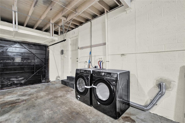 garage featuring washer and dryer and concrete block wall