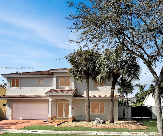 view of front of property featuring a garage, a tiled roof, decorative driveway, and stucco siding