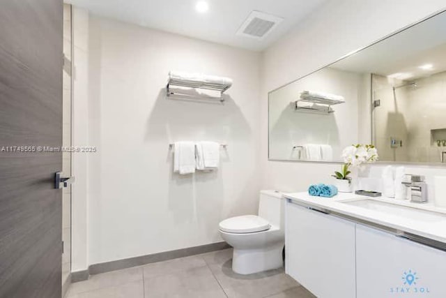 bathroom featuring toilet, vanity, visible vents, a shower stall, and tile patterned floors