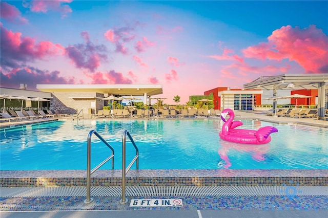 pool at dusk with a patio and a community pool