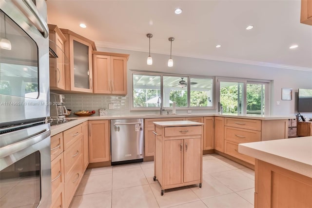 kitchen featuring light countertops, stainless steel appliances, a sink, and light brown cabinetry