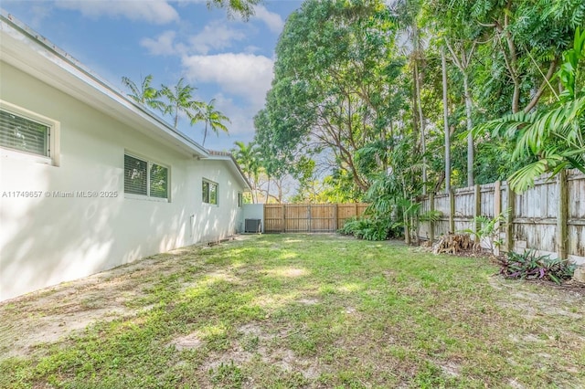 view of yard with a fenced backyard and central air condition unit