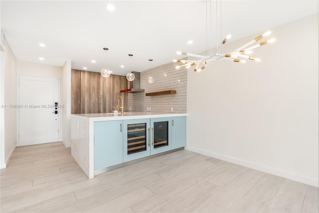 bar with decorative light fixtures, a sink, wet bar, beverage cooler, and wall chimney exhaust hood