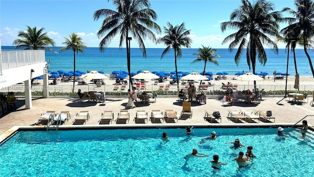 community pool featuring a water view and fence