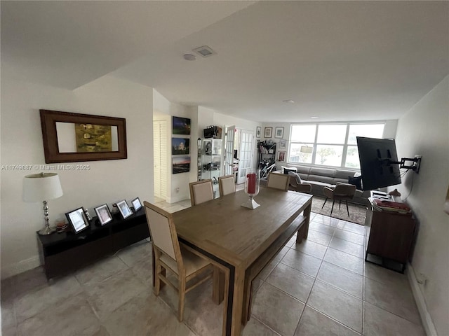 dining room with light tile patterned floors, visible vents, and baseboards
