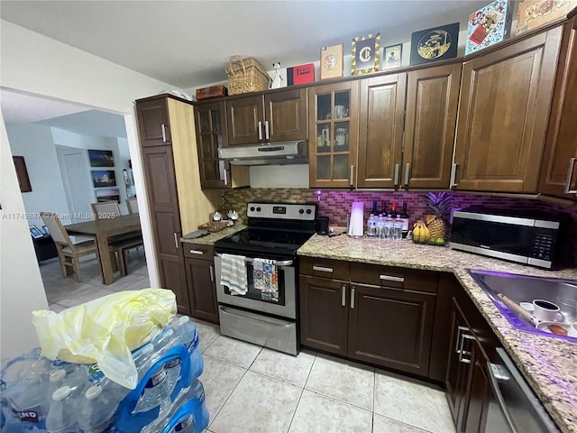 kitchen featuring stainless steel appliances, dark brown cabinets, backsplash, and under cabinet range hood