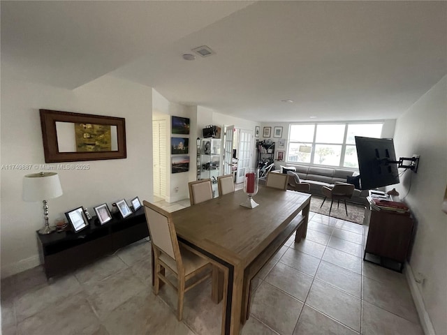 dining room featuring light tile patterned floors, baseboards, and visible vents