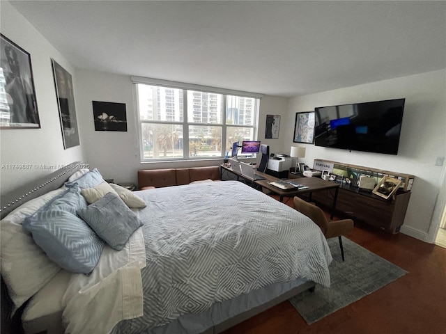 bedroom with baseboards and wood finished floors