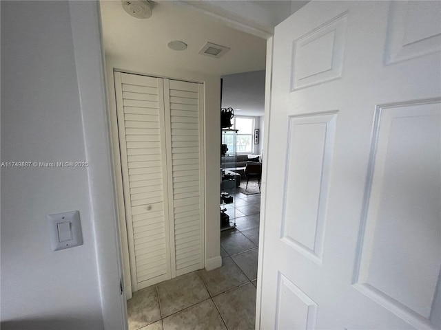 hall featuring light tile patterned floors and visible vents