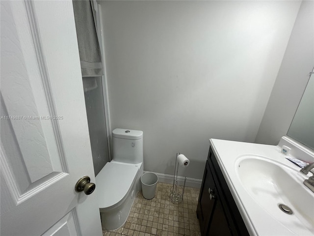 bathroom with toilet, baseboards, and vanity