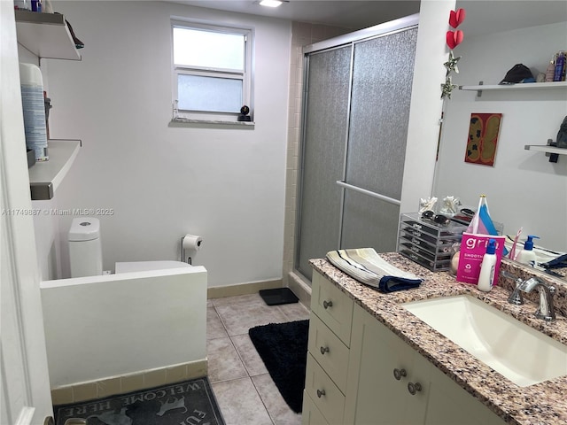 bathroom featuring baseboards, a shower stall, tile patterned flooring, and vanity