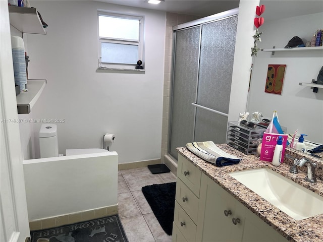 bathroom featuring baseboards, a shower stall, vanity, and tile patterned floors