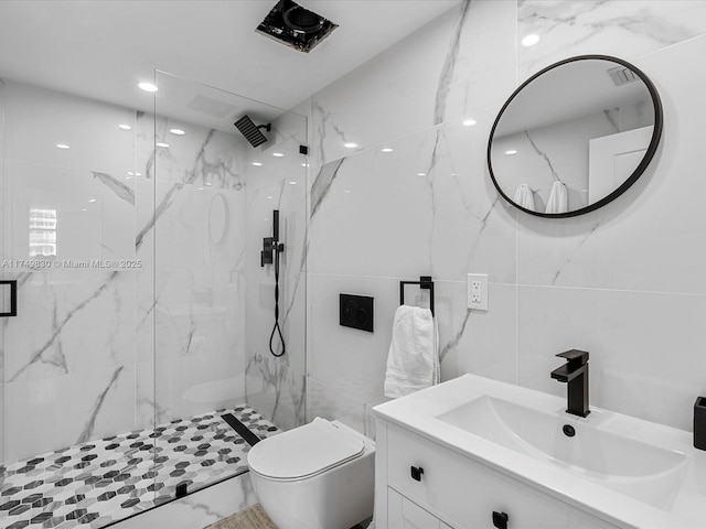 full bath featuring toilet, vanity, visible vents, tile walls, and a marble finish shower