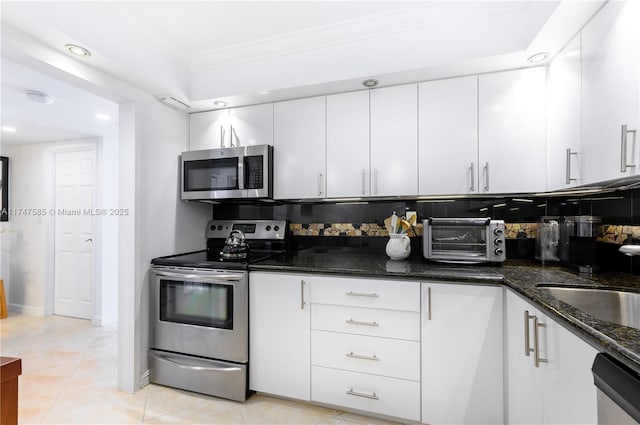 kitchen with a toaster, appliances with stainless steel finishes, and white cabinets