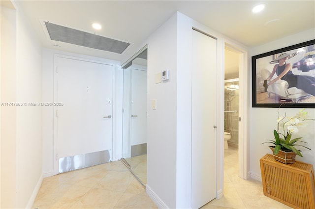 hall featuring baseboards, light tile patterned flooring, visible vents, and recessed lighting