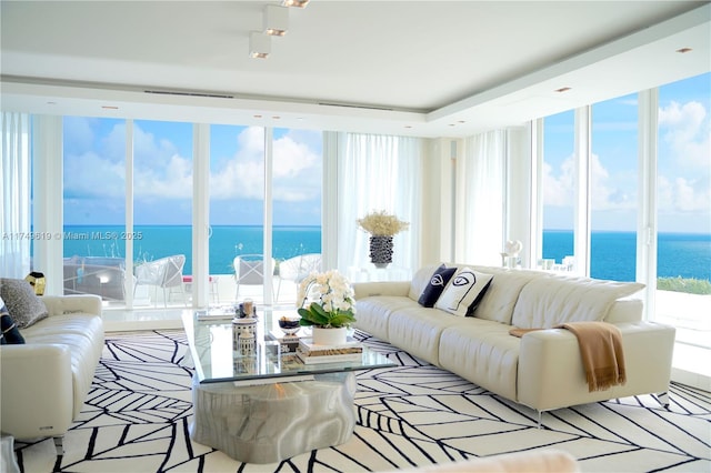 living area with a water view and expansive windows